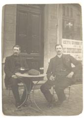 Twee mannen aan een tafeltje op straat
