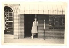 Winkeljuffrouw aan de winkeldeur